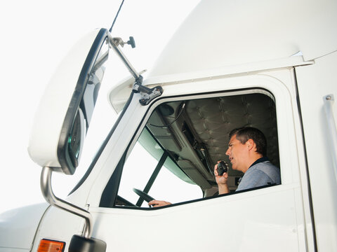 Truck driver sitting in truck and talking on CB radio