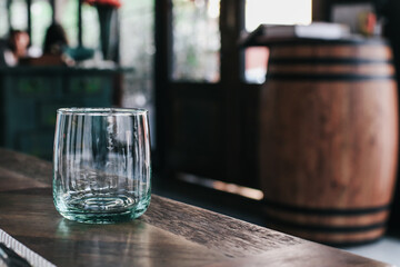 Empty glass on the dark wooden table at restaurant.