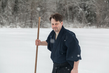 samurai warrior walks with sword and staff across an empty winter field