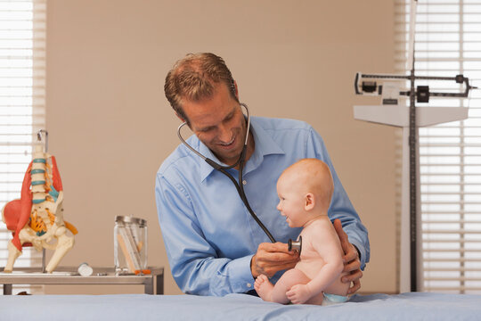 Pediatrician listening heartbeat of baby boy (2-5 months)