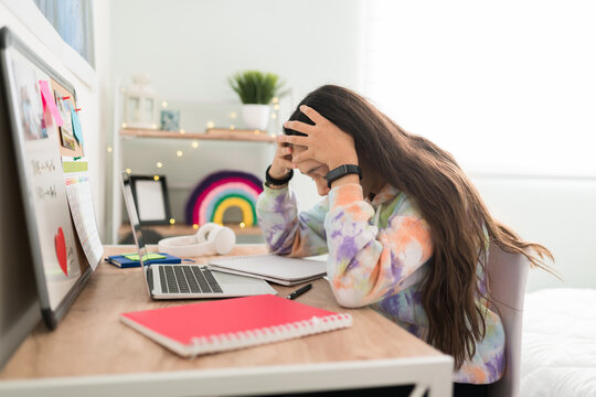 Overwhelmed teen girl with a headache holding her head