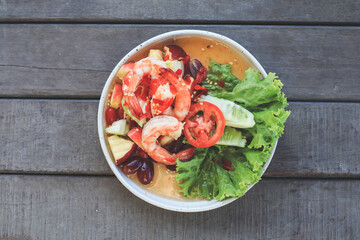 Spicy Thai fruit salad with Shrimps on wooden table at cafe , Thai spicy style healthy food Thai cuisine.