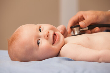Pediatrician listening heartbeat of baby boy (2-5 months)