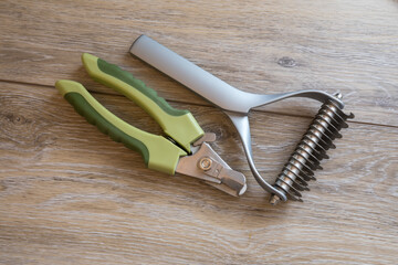 Dog grooming and bathing tools close up. 2 sided undercoat rake, nail clipper.