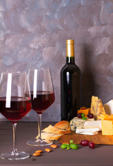 Glasses and bottle of red wine with cheese and nuts. Copy space