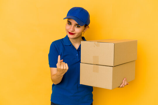 Young skinny delivery arab girl pointing with finger at you as if inviting come closer.