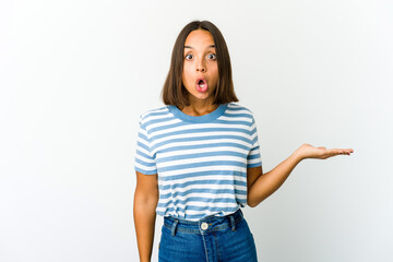 Young mixed race woman impressed holding copy space on palm.