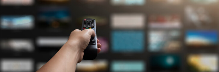 concept - man with his remote control watching tv in his living room