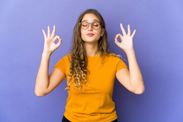 Young caucasian cute woman relaxes after hard working day, she is performing yoga.