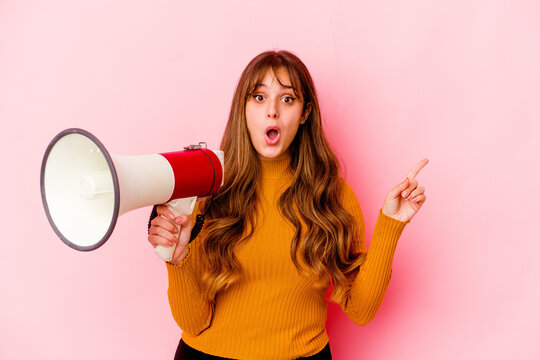 Young Caucasian Woman Holding A Megaphone Isolated Pointing To The Side