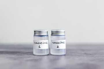 covid-19 vaccine race and immunisation against the pandemic, ampoules with Vaccine 1 and Vaccine 2 labels side by side