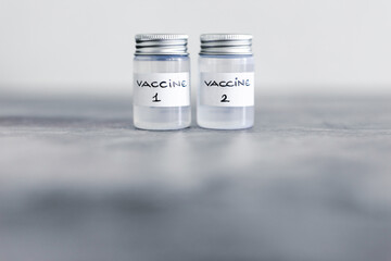 covid-19 vaccine race and immunisation against the pandemic, ampoules with Vaccine 1 and Vaccine 2 labels side by side