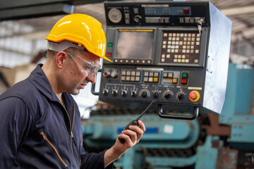 Portrait of male worker talking on radio phone calling team worker. machine technology invention industry manufacturing factory