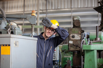 Portrait of a worker in a factory. Portrait of industrial worker indoors in factory. Young technician with hard hat.