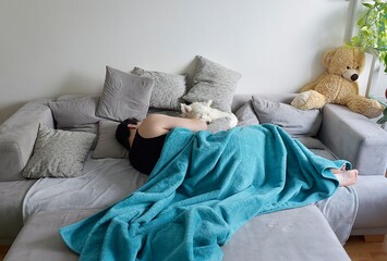 man sleeping on a sofa with a white dog