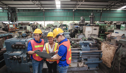 worker Industrial Engineers Talk with Factory Worker while Using Laptop. industrial worker is working. technician engineer and mentor checking process. machine metalworking industry concept copyspace