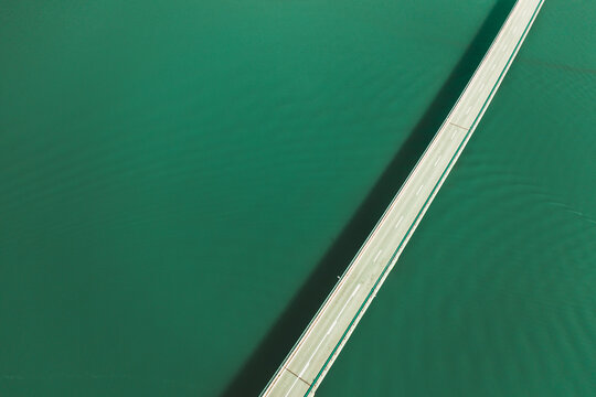 Aerial view of a car driving on the bridge crossing Pant&agrave; de la Baells lake near Cercs, Catalonia, Spain.
