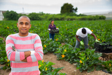 Portrait of latino hired worker on the farm field