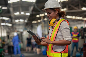 Engineer Female in using Tablet in Foundry worker in factory on the machine. portrait of an industrial Femal engineer with tablet in a factory.