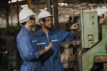 Naklejka na ściany i meble Two people working. Male Industrial Engineers Talk with Factory Worker while Using tablet.