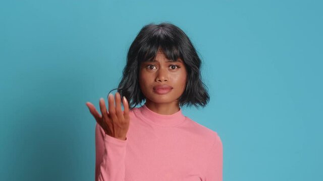Asian American woman gestures and asks someone demands answer makes facepalm with disappointment feels unhappy or frustrated cannot hear what she wants dressed in pink long sleeve poses indoor