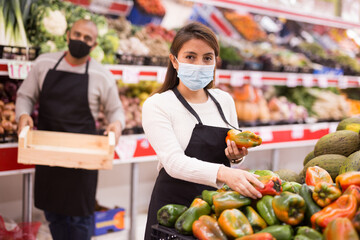 Obraz premium Latin supermarket workers in personal protective equipment during coronavirus quarantine