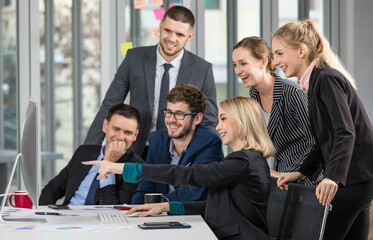 Group of businesspeople team sitting in conference together in an office with intimate and look at computer sreen. Idea for a good relationship of teamwork in business