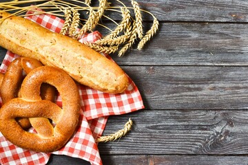 bread and wheat.Fresh bread with napkin and wheat ears on a wooden table. Copy space, flat lay.