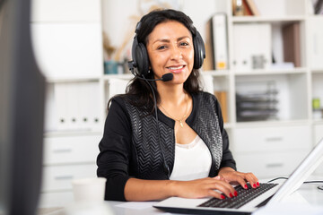 Portrait of positive latin american woman customer support phone operator at workplace