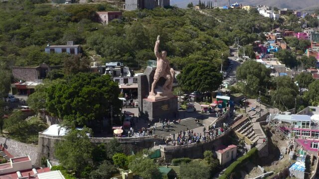 Aerial: Pipila statue and people walking in the park, drobe view