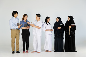 Obraz premium Asian men and women of different religions have Buddhism, Muslims, Christ. bible Quran. A smiling face wearing religious clothes, white background. Concept religious ideas teach love, faith, desire.