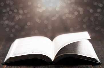 A Bible Open on a Rustic Wooden Table with Pages Blowing Open