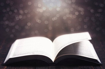 A Bible Open on a Rustic Wooden Table with Pages Blowing Open