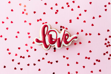 Gingerbread cookies love with red heart glitter. Valentine card. Pink background