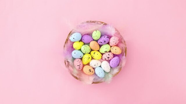 Easter colorful eggs move in circle in wooden basket with feathers. Stop motion