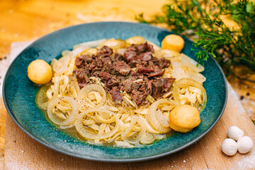 Asian national dish beshparmak with meat and baurski on a decorated table