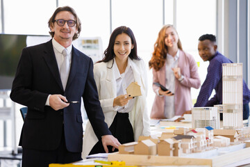 A woman caucasian smilling picks up a model of the house. to inquire about working with business...