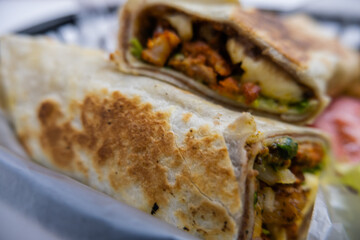 Spicy pork burritos and lettuce in a plastic basket