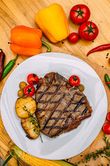 t-bone steak with grilled vegetables on a decorated table