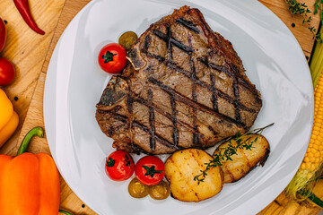 t-bone steak with grilled vegetables on a decorated table