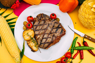 t-bone steak with grilled vegetables on a decorated table