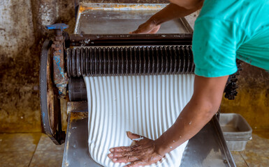 The farmer making rubber sheets hang on bamboo process dry by solar energy . A raw rubber latex...