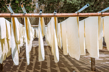 The farmer making rubber sheets hang on bamboo process dry by solar energy . A raw rubber latex...