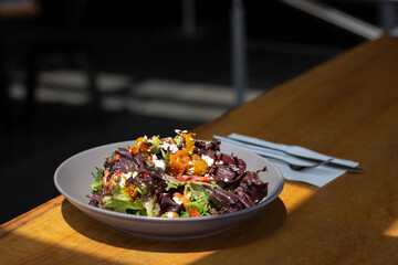 Fresh summer Salad on table with pumpkin, feta and mixed greens. Great on it's own, for social media or for a poster.
