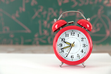 The alarm clock in front of the blackboard