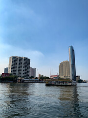 Obraz premium anuary 2 2021 - Bangkok, Thailand : Beautiful Landscape of high modern building and Ferry at Chao Praya River, Bangkok, Thailand