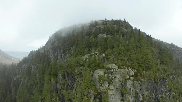 Scenic View At The Peak Of Skyrim Mountain In Norway Surrounded With Lush Green Trees - Aerial Shot