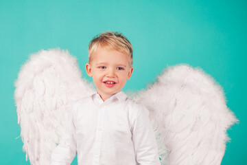 Portrait of little blond Angel boy. Child with angelic white dress. Toddler boy wearing angel...