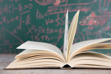 Books opened in front of the blackboard