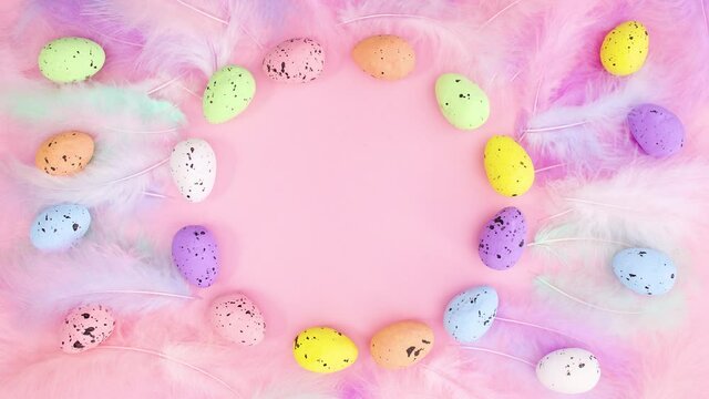 Easter eggs move in circle surrounded by feathers. Stop motion